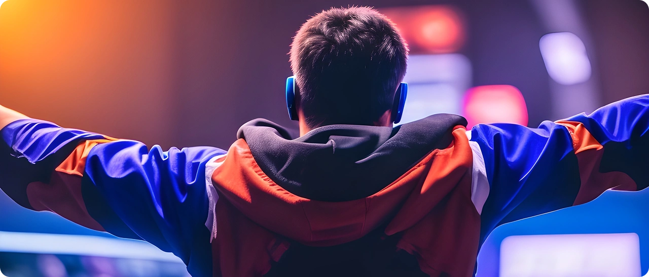 Een speler staat met opgeheven armen op het podium na zijn overwinning in een esports-toernooi