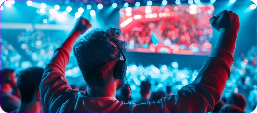 Een speler met opgeheven armen viert zijn overwinning in de arena met felle lichten